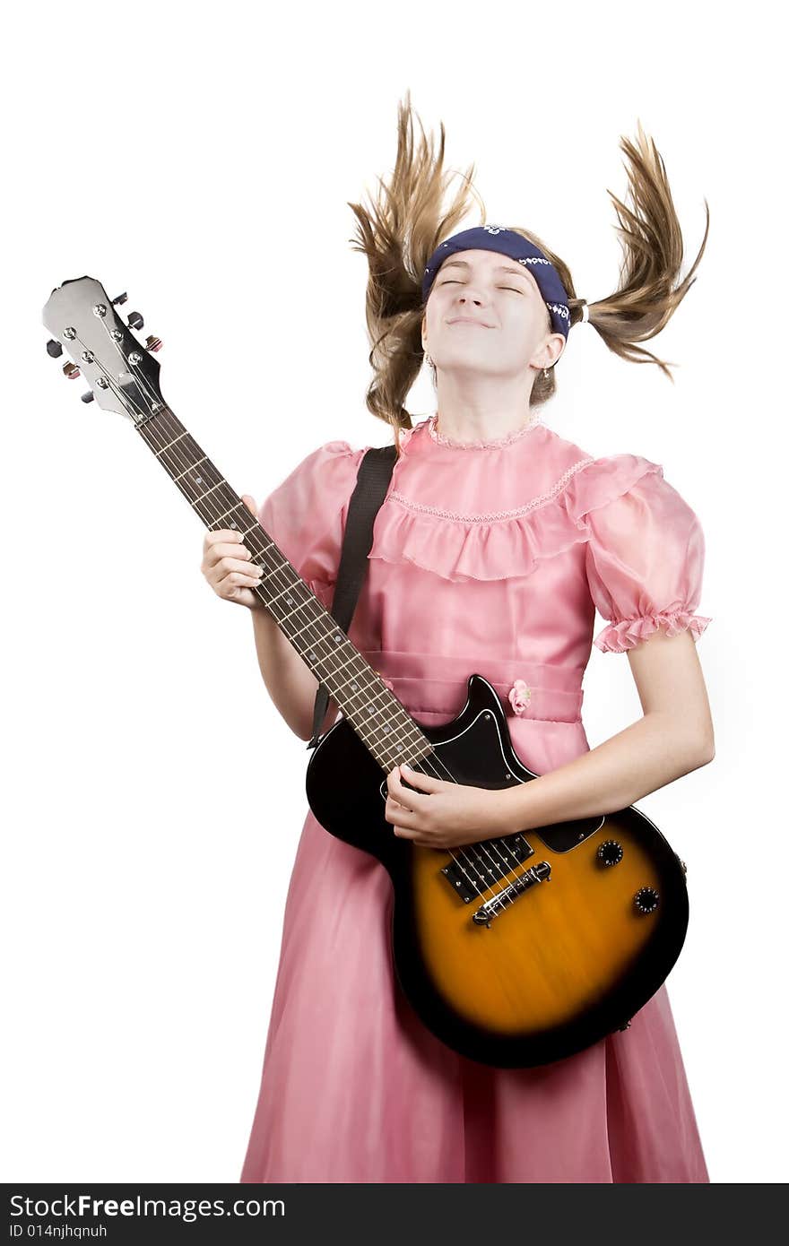 Young girl in a pink dress head-banging with an electric rock guitar. Young girl in a pink dress head-banging with an electric rock guitar