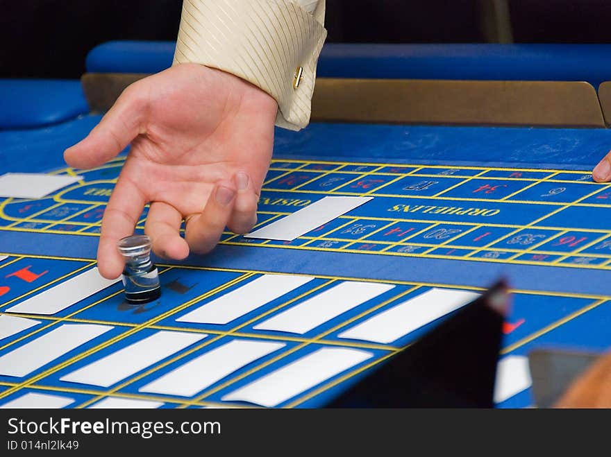 Croupiers hands under the blue roulette table. Croupiers hands under the blue roulette table