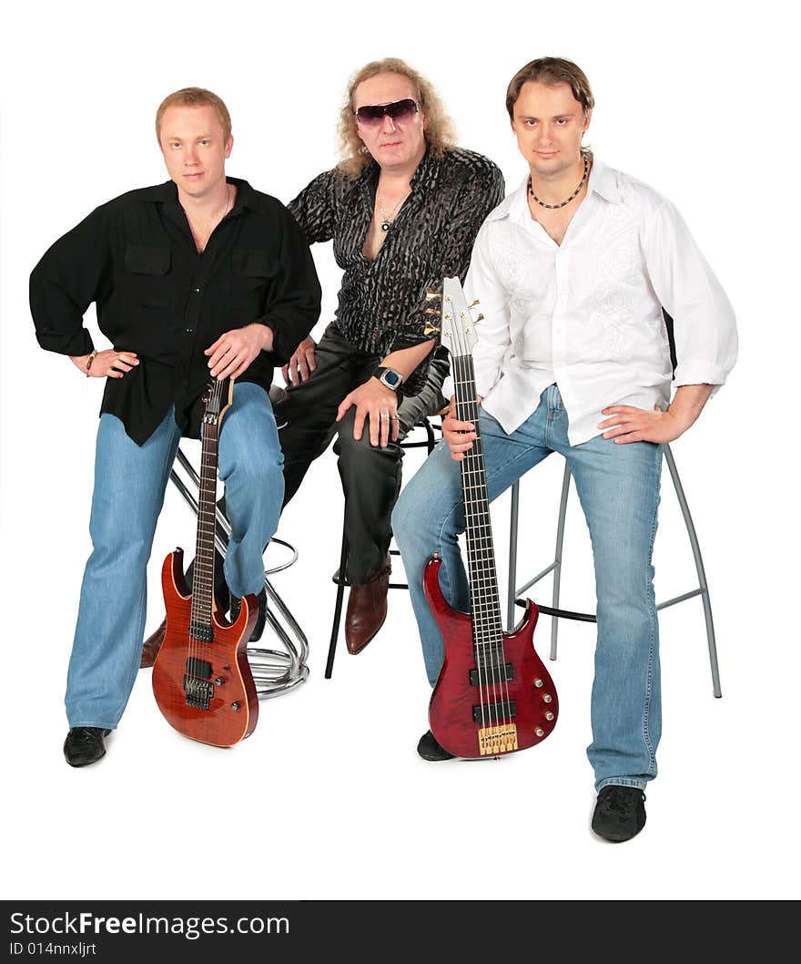 Three sitting men with two guitars. Music group.