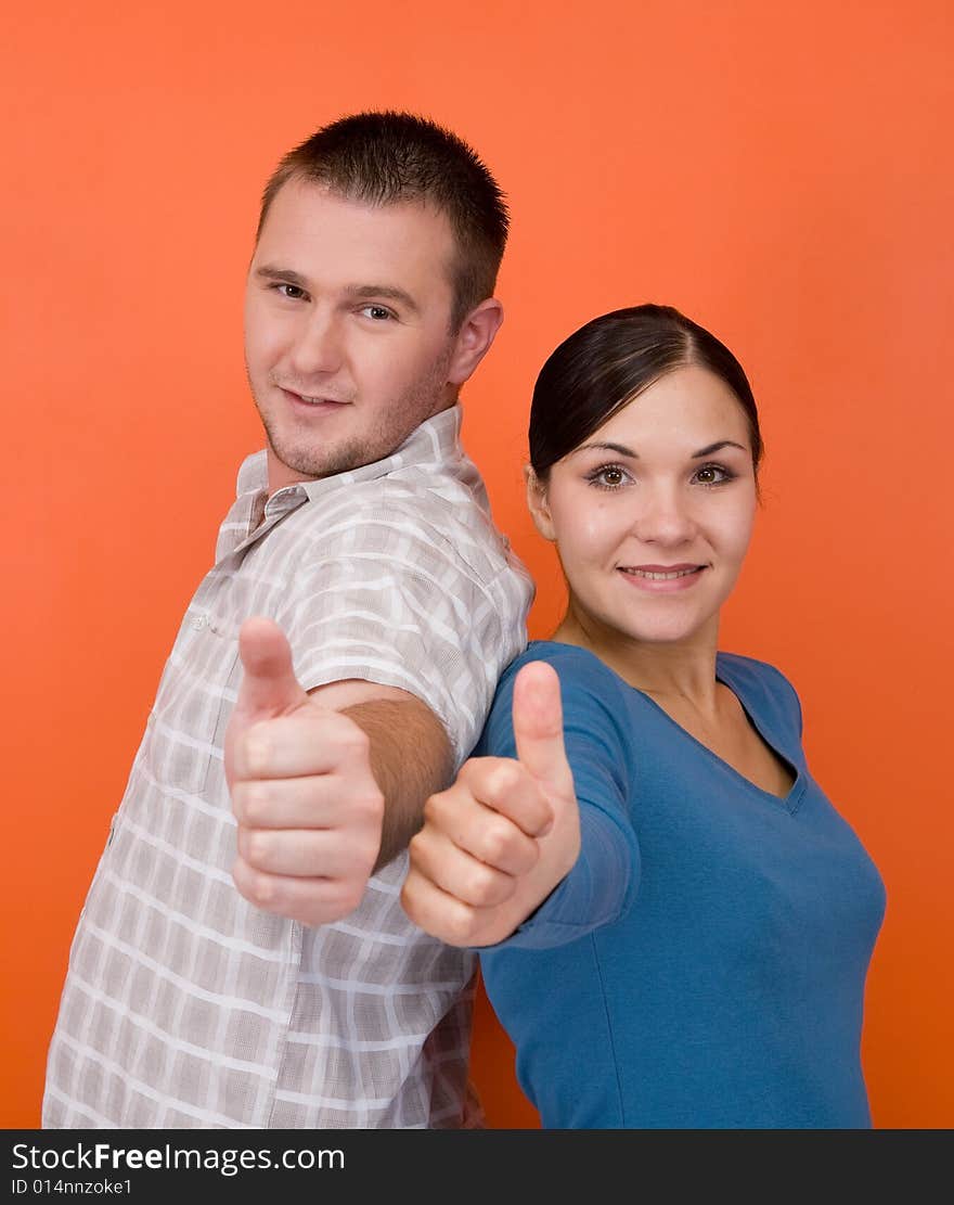 Casual couple together standing on orange background. Casual couple together standing on orange background