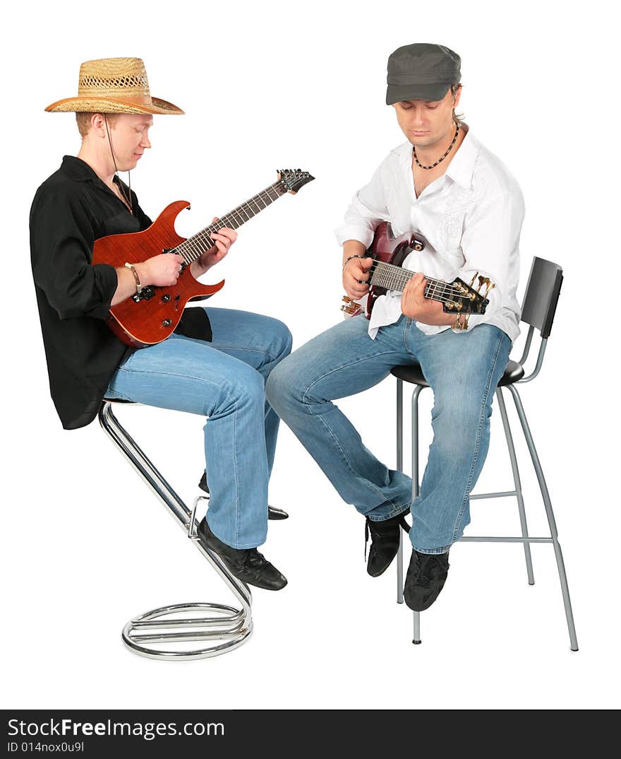 Two sitting men in hats  play on guitars