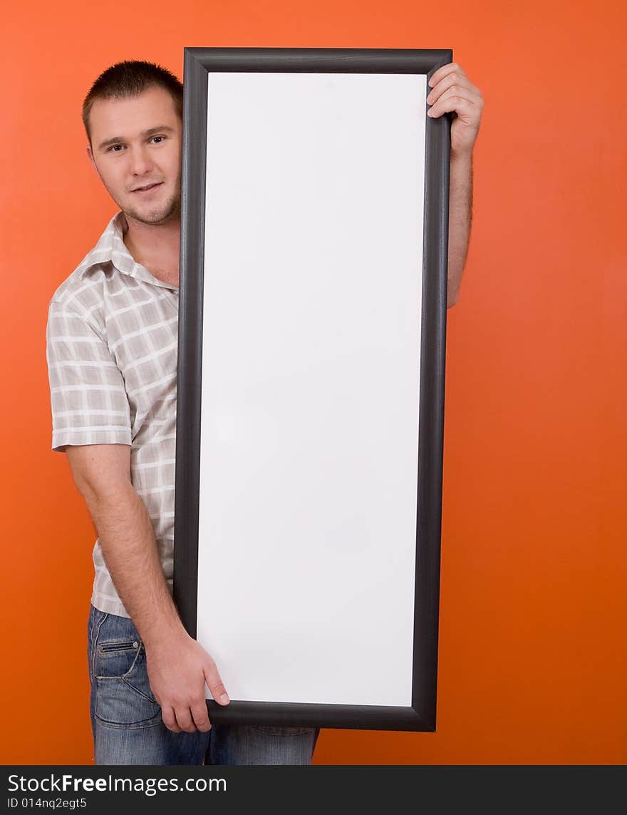 Casual guy standing with banner on orange background. Casual guy standing with banner on orange background