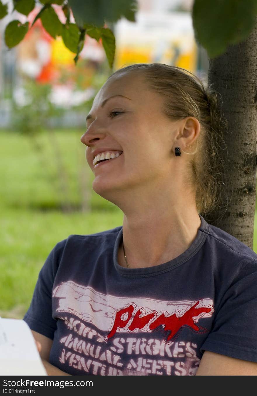 Portrait of laughing woman under the tree