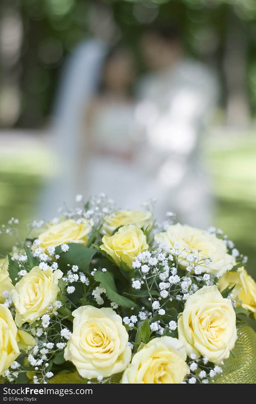 Bunch of white roses and newly-weds on a green background. Bunch of white roses and newly-weds on a green background