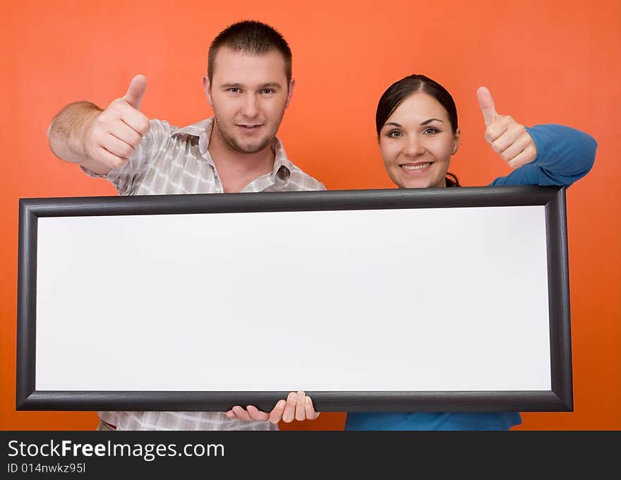 Casual couple together standing on orange background. Casual couple together standing on orange background