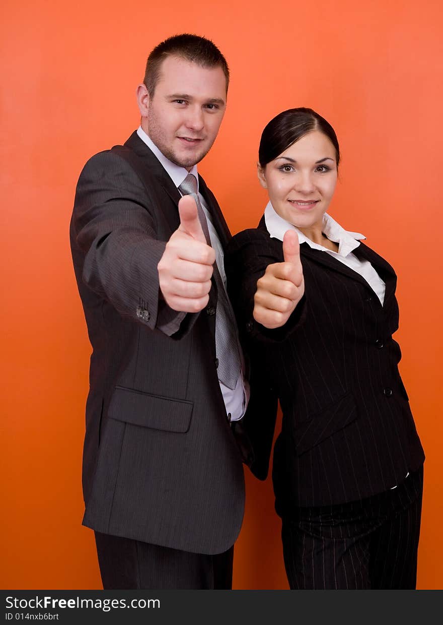 Woman and man in team standing on orange background. Woman and man in team standing on orange background