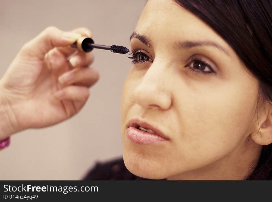 Young woman being make up by a makeup artist.