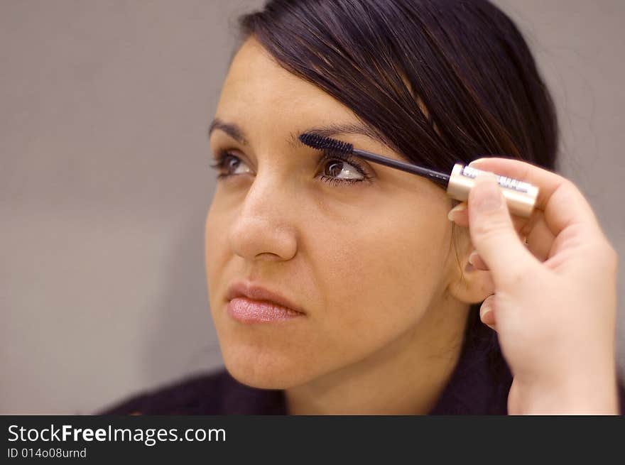 Young woman being make up by a makeup artist. Young woman being make up by a makeup artist.