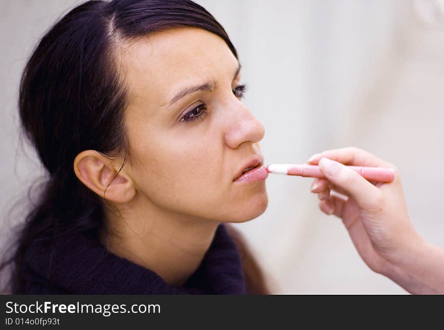 Young woman being make up by a makeup artist. Young woman being make up by a makeup artist.