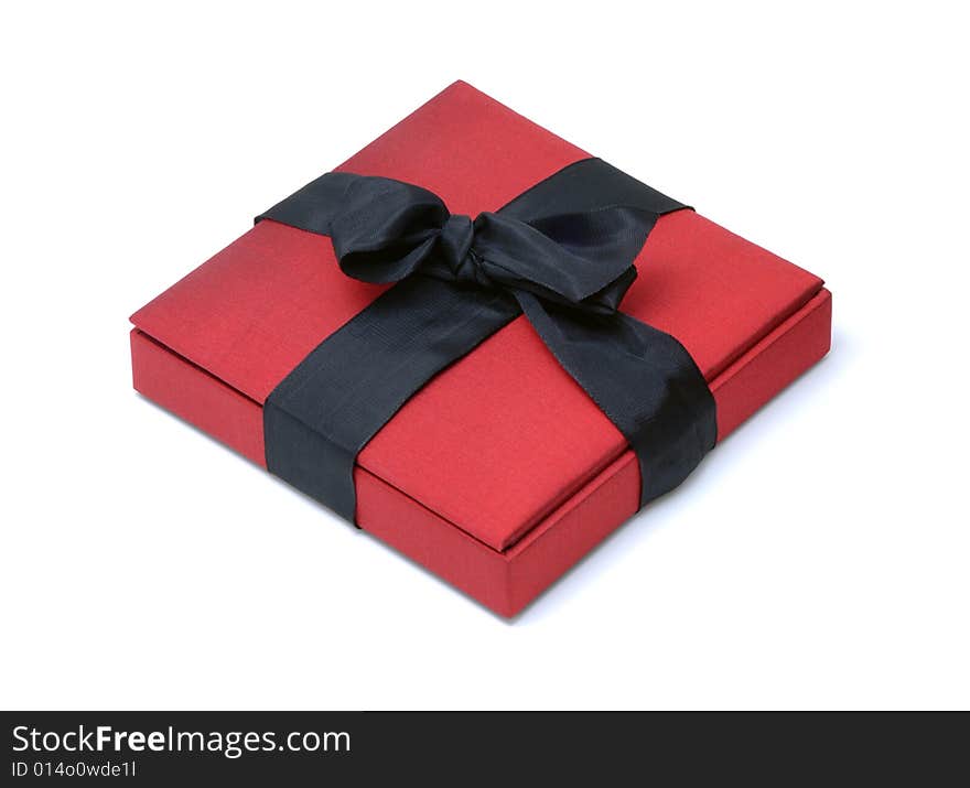 Red Silk Gift Box with a Black Ribbon Bow on an Isolated Background. Red Silk Gift Box with a Black Ribbon Bow on an Isolated Background