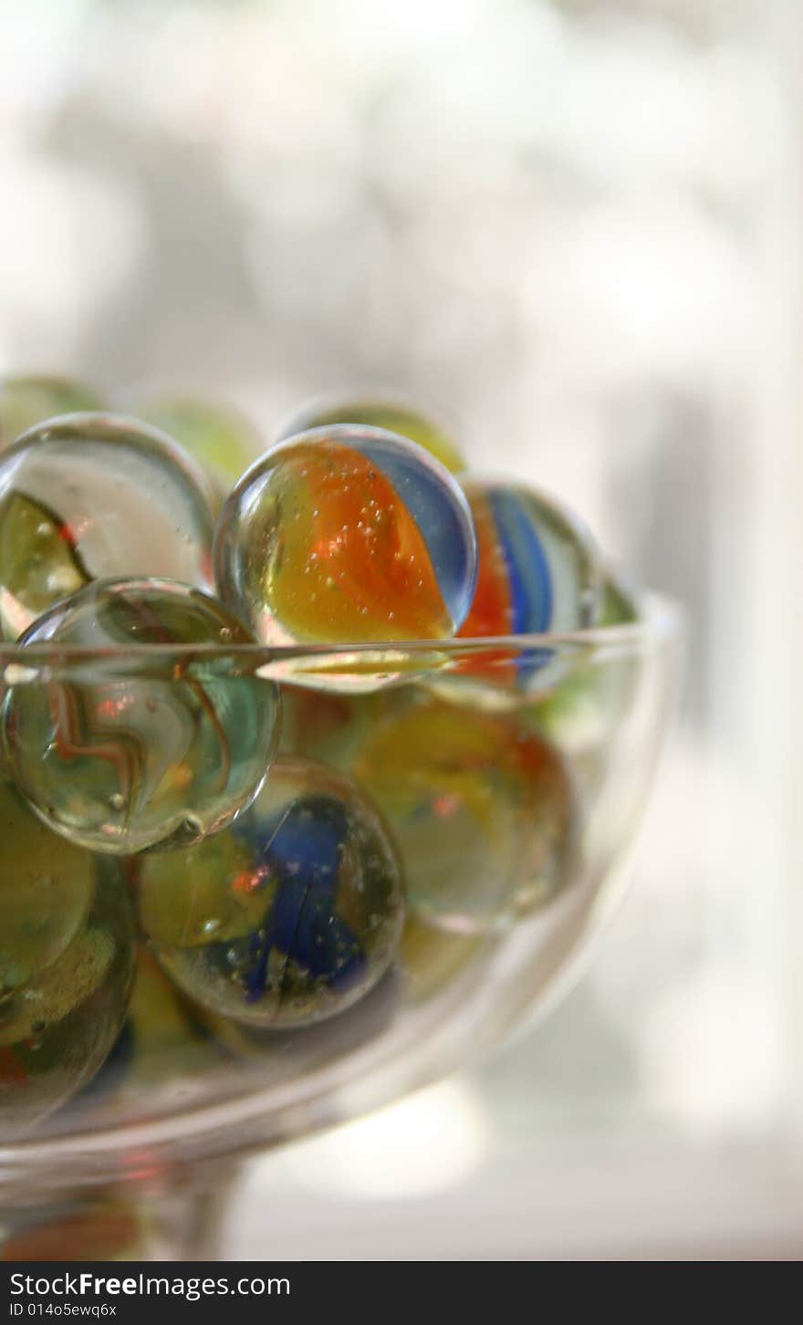 A glass is full of colorful marbles. A glass is full of colorful marbles.