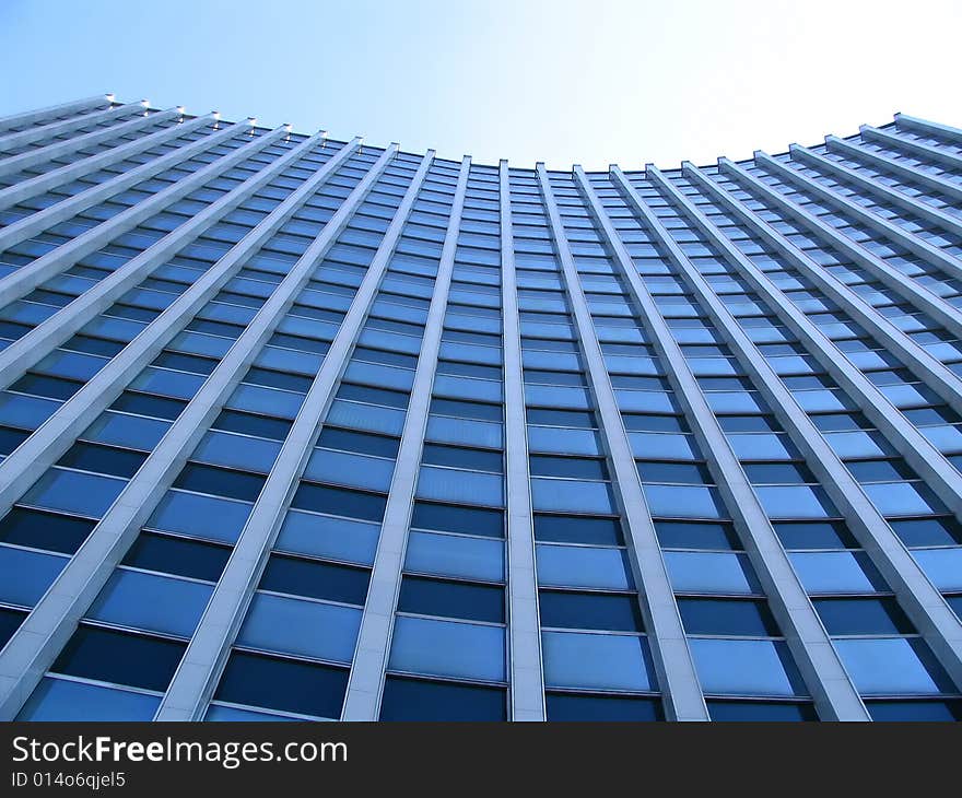 Highrise glass building with sky and clouds reflection