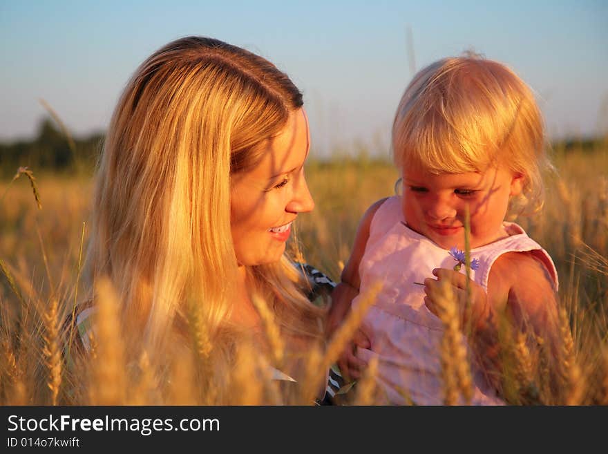 Mother With Child Sit In Wheaten Field