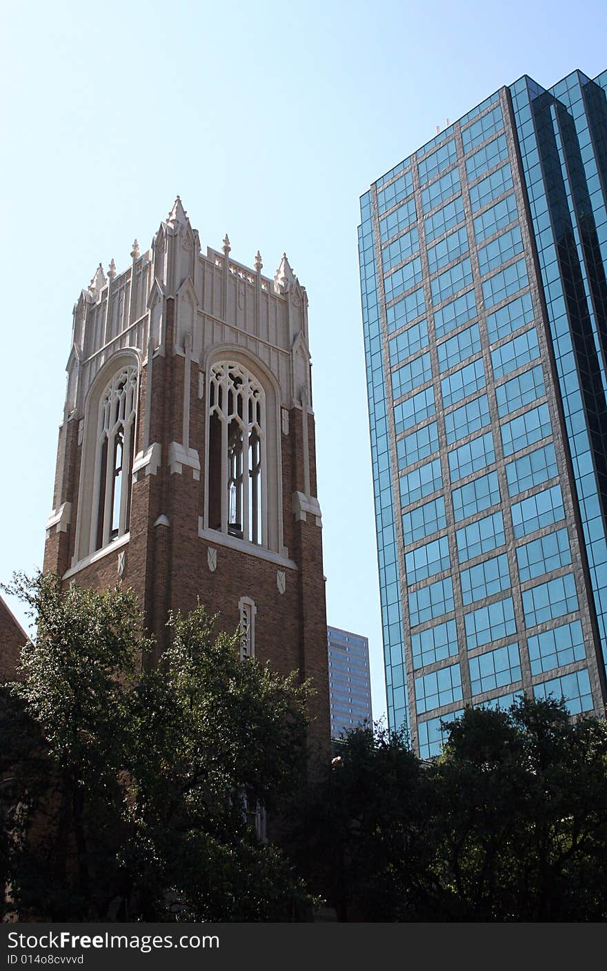 A modern skyscraper stands next to a traditional church bell tower. A modern skyscraper stands next to a traditional church bell tower.