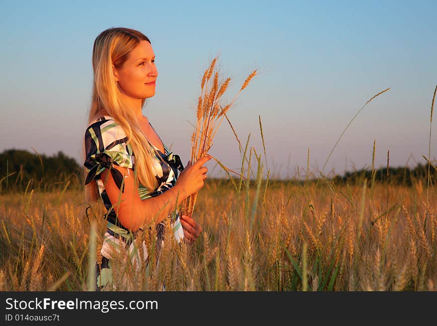 Young woman with earns  on a wheaten field