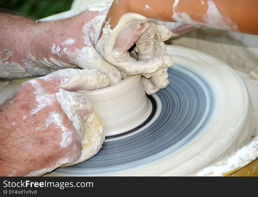 Teacher Showing Student how to make Pottery on a Turning Wheel. Teacher Showing Student how to make Pottery on a Turning Wheel