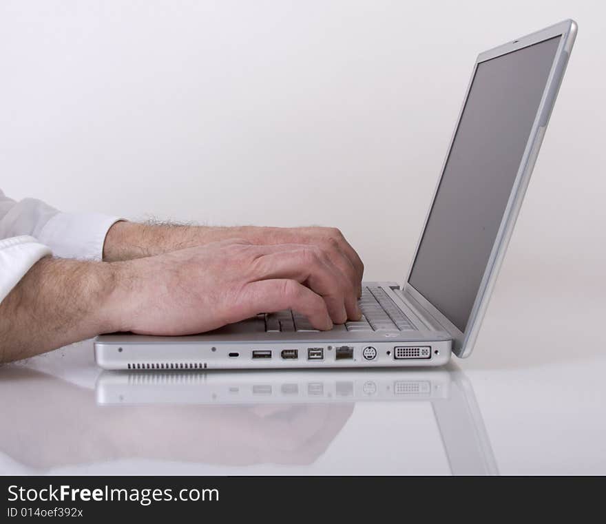 Man's hands typing on a laptop computer. Man's hands typing on a laptop computer