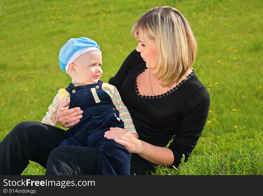 Mother And Chld Sit On Meadow