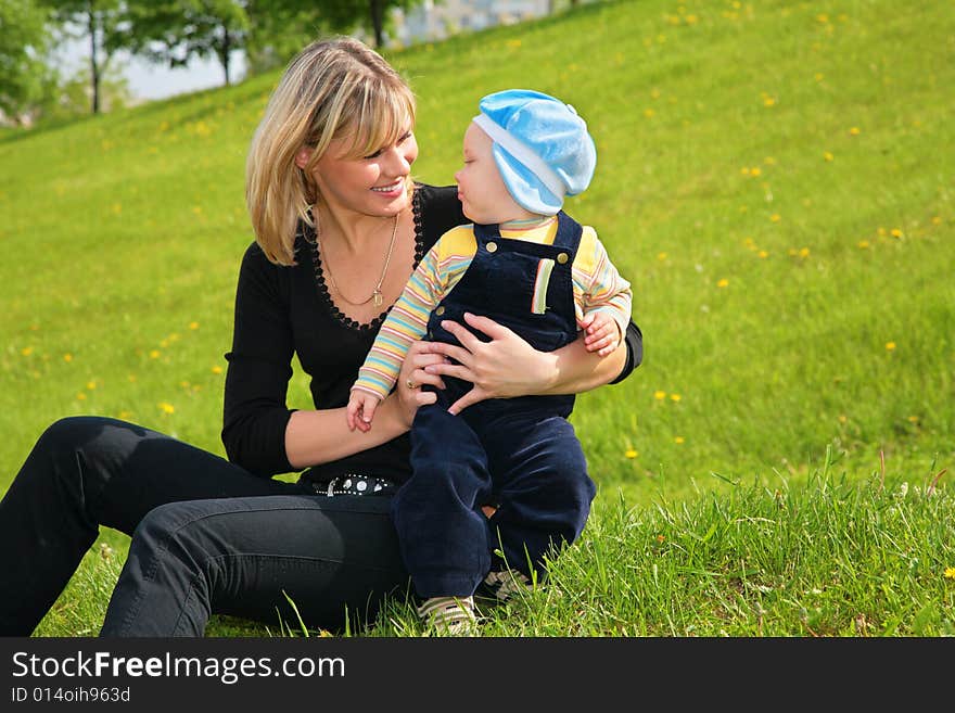 Mother with baby sit on green grass. Mother with baby sit on green grass