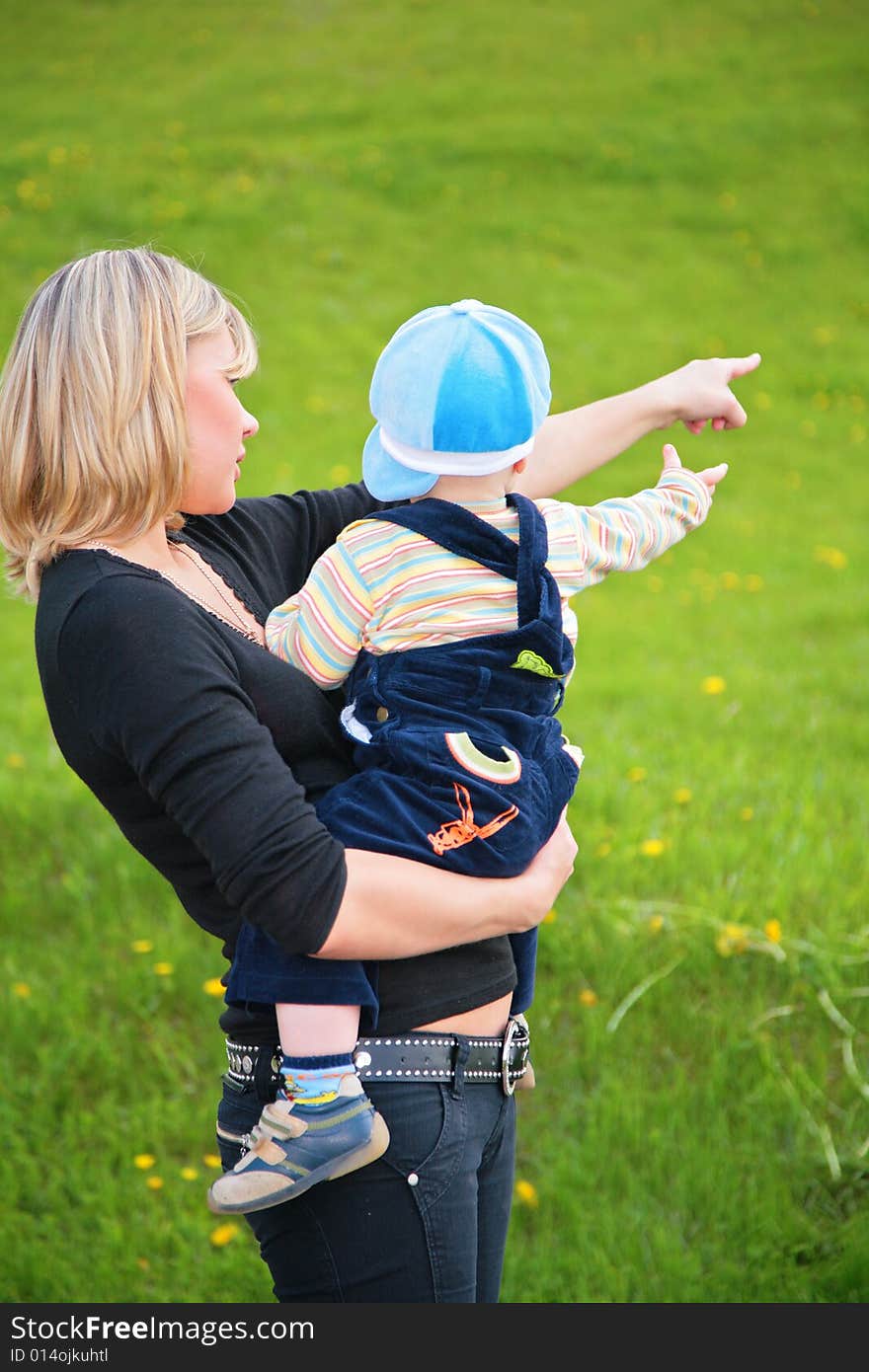 Mother Keeps Child In Her Arms And Points To Somet