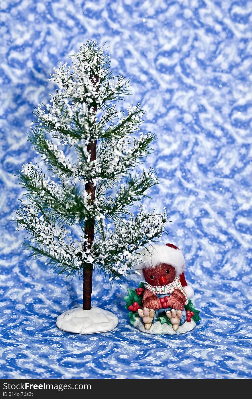 Winter tree with cute cardinal decoration on a blue winter background.