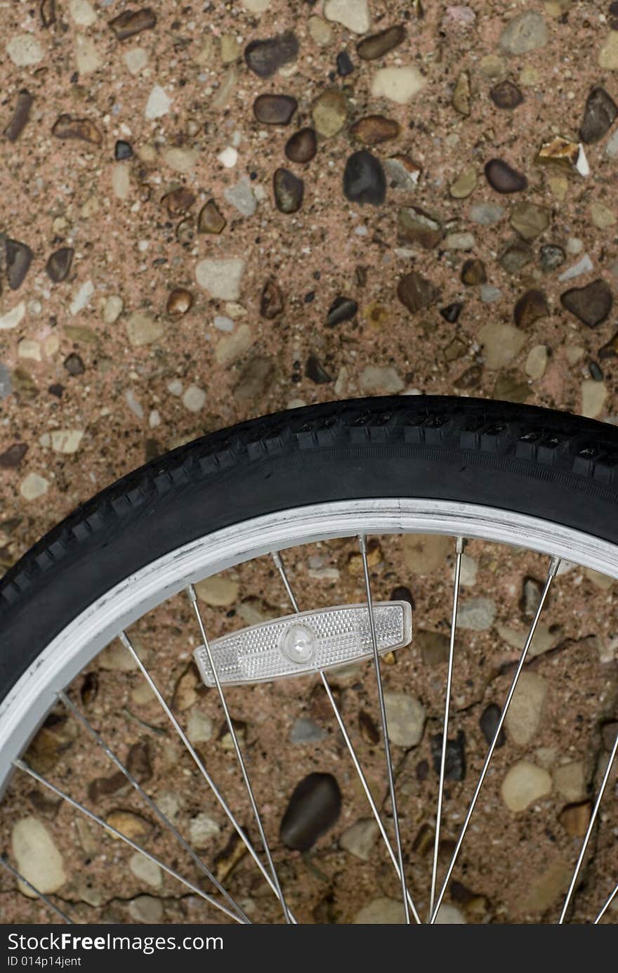 Black bicycle tire laying on rocky road