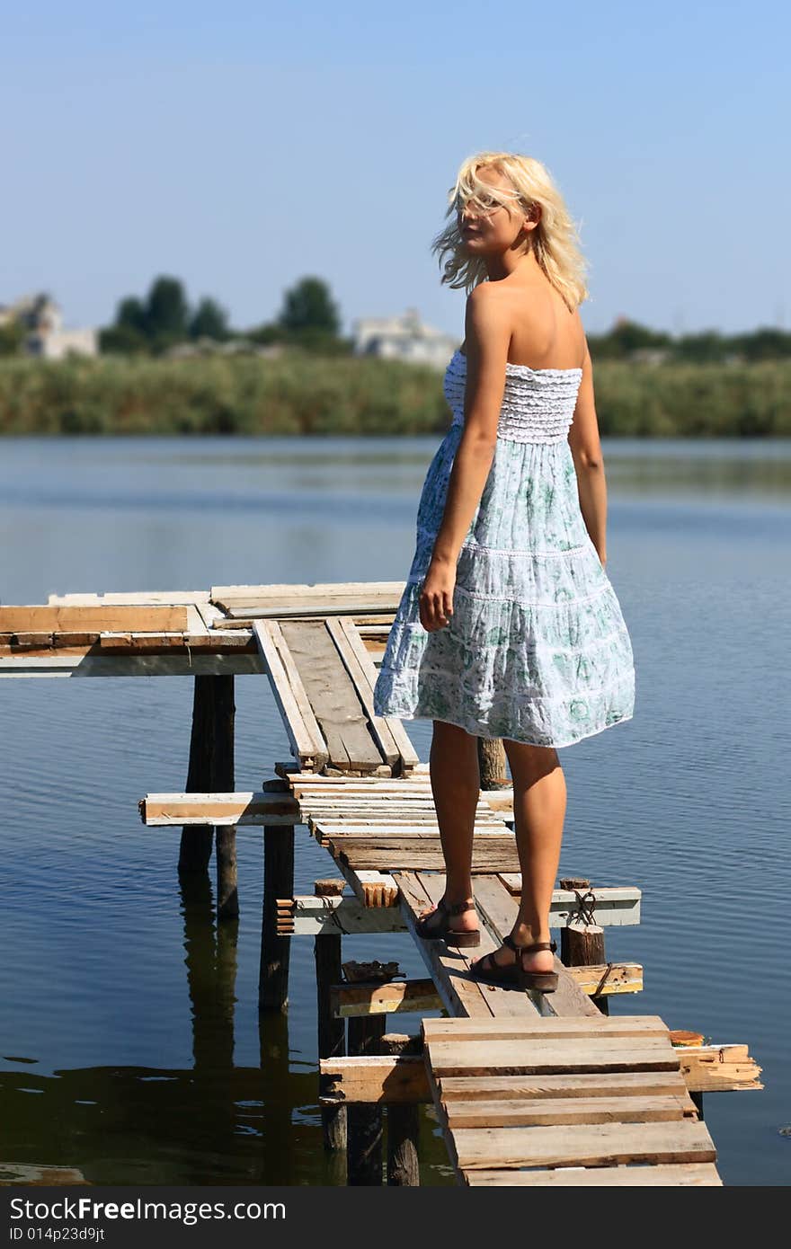 Girl walking along the pier on a hot sunny day