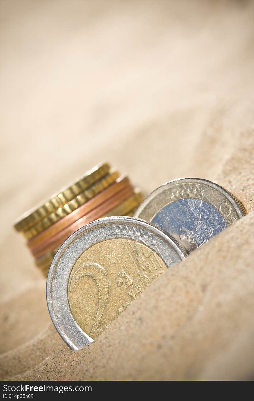 Euro coins in the sand. Euro coins in the sand