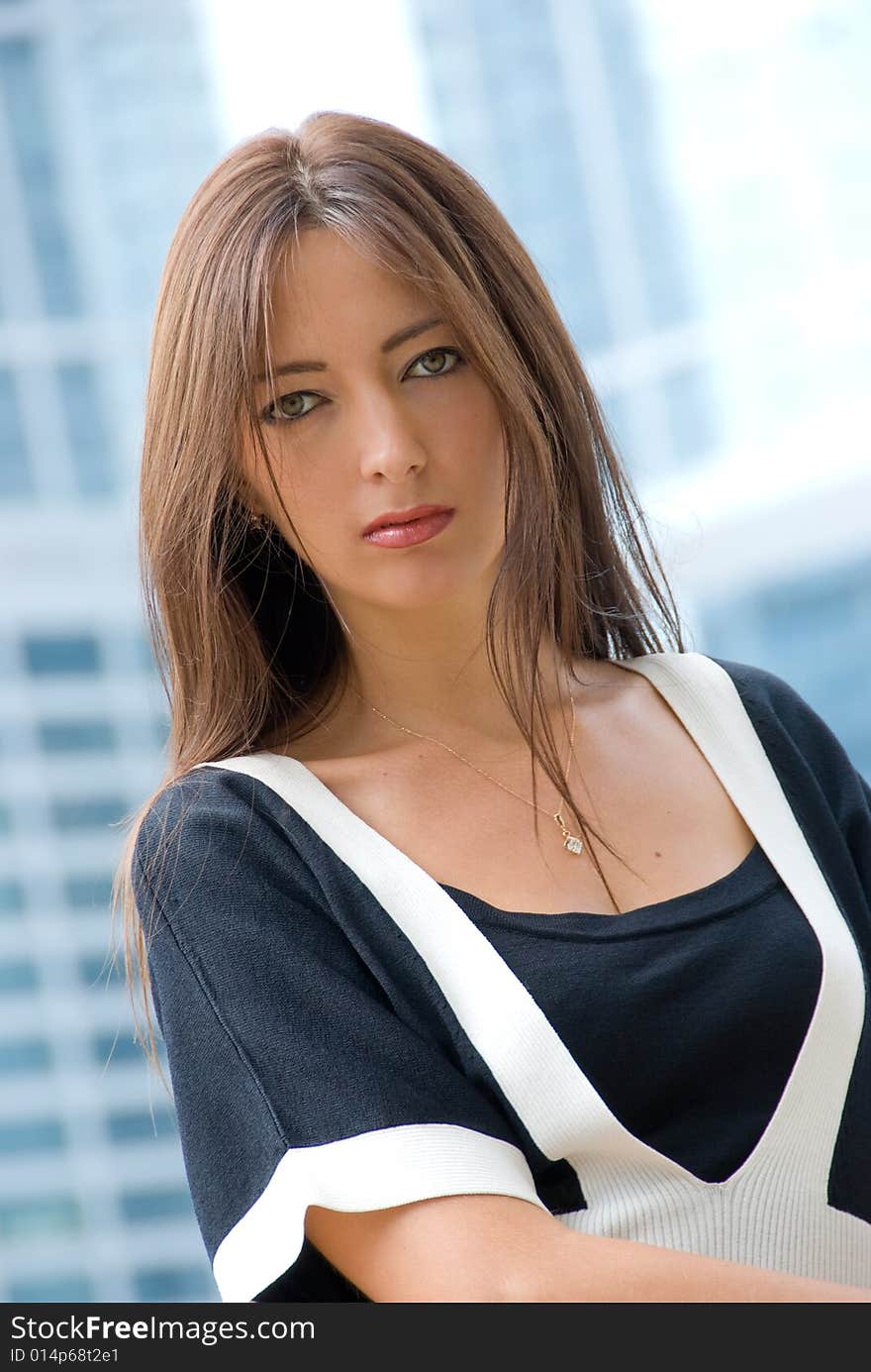 Portrait of young business woman. Modern buildings on the background.