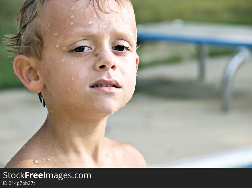 Young boy still dripping with water after swimming in the pool. Young boy still dripping with water after swimming in the pool.