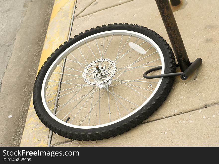 Bike tire locked to brown pole. Bike tire locked to brown pole