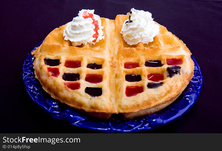 Waffle with cream and coating with chocolate and strawberry syrup