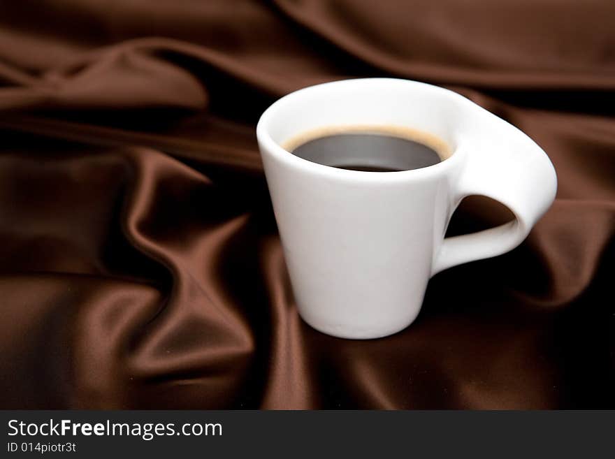 Cup of coffee on brown background