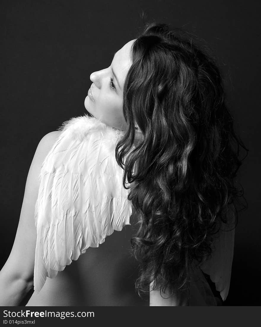 Pregnant woman on a black background with angel wings. Pregnant woman on a black background with angel wings