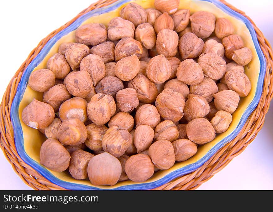 Nuts in a wooden plate on a white background