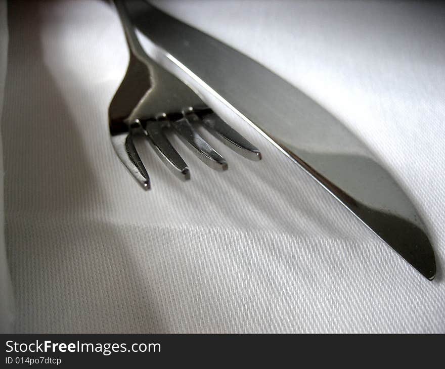 Fork with knife on the white covered table