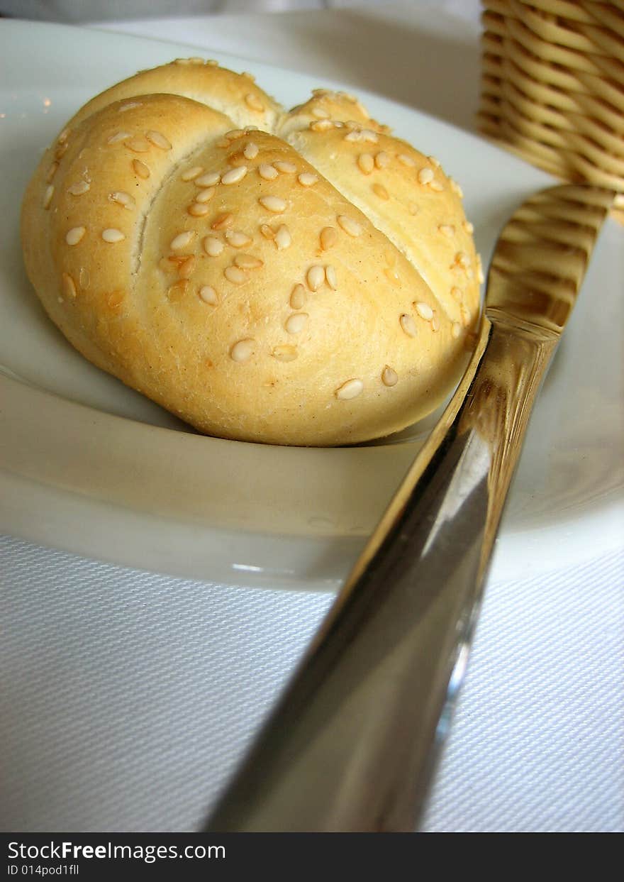 Bun with knife and bread's tidy on a white cover. Bun with knife and bread's tidy on a white cover