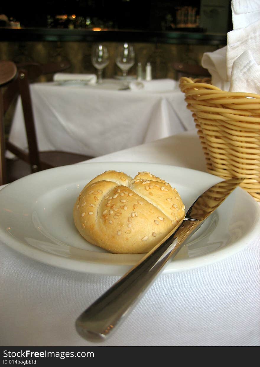 Bun on a plate with a knife and basket. Bun on a plate with a knife and basket