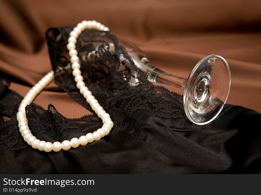 Cup and white pearls on brown background. Cup and white pearls on brown background