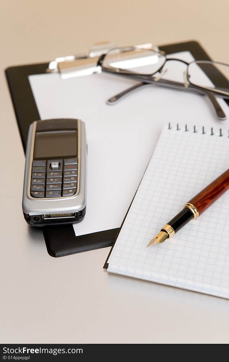 Mobile phone and glasses on table. Mobile phone and glasses on table