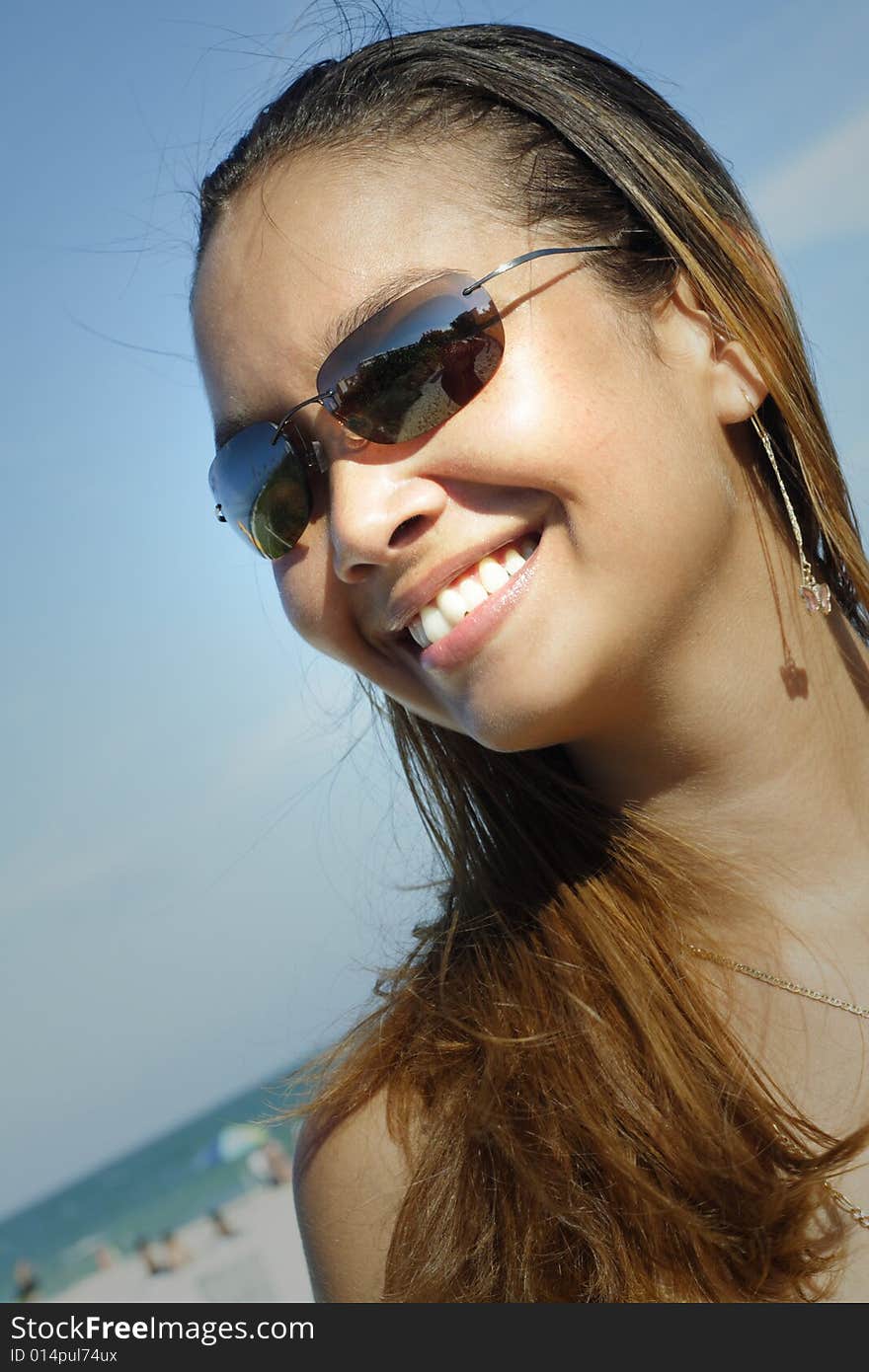 Image of a young woman smiling on a blue sky. Image of a young woman smiling on a blue sky