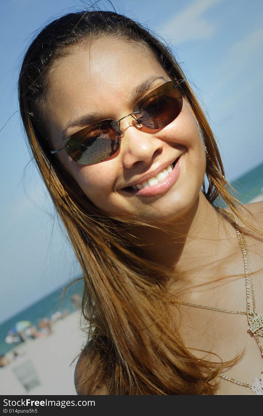 Image of a young woman smiling on a blue sky. Image of a young woman smiling on a blue sky