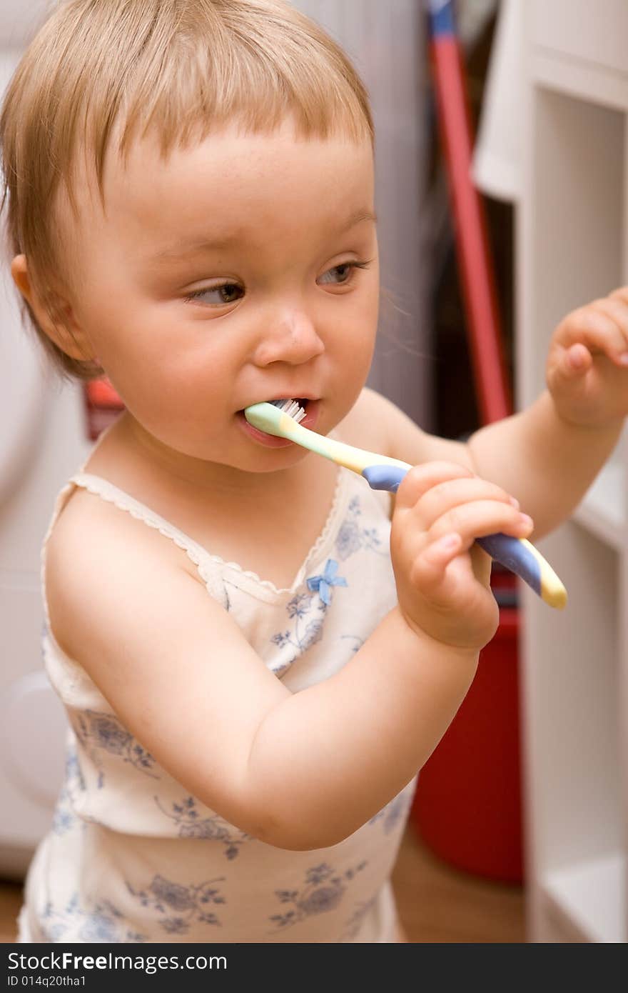 Sweet girl brushing teeth in bathroom