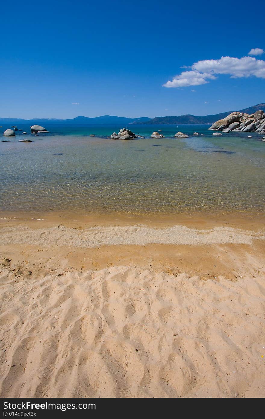 Beach and water, with rocks and blue sky