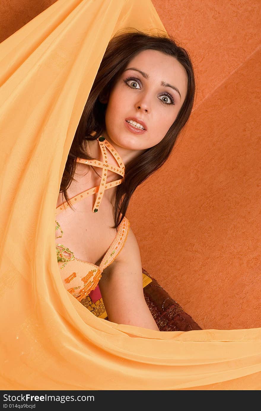 The beautiful girl in east order on a orange background. The beautiful girl in east order on a orange background