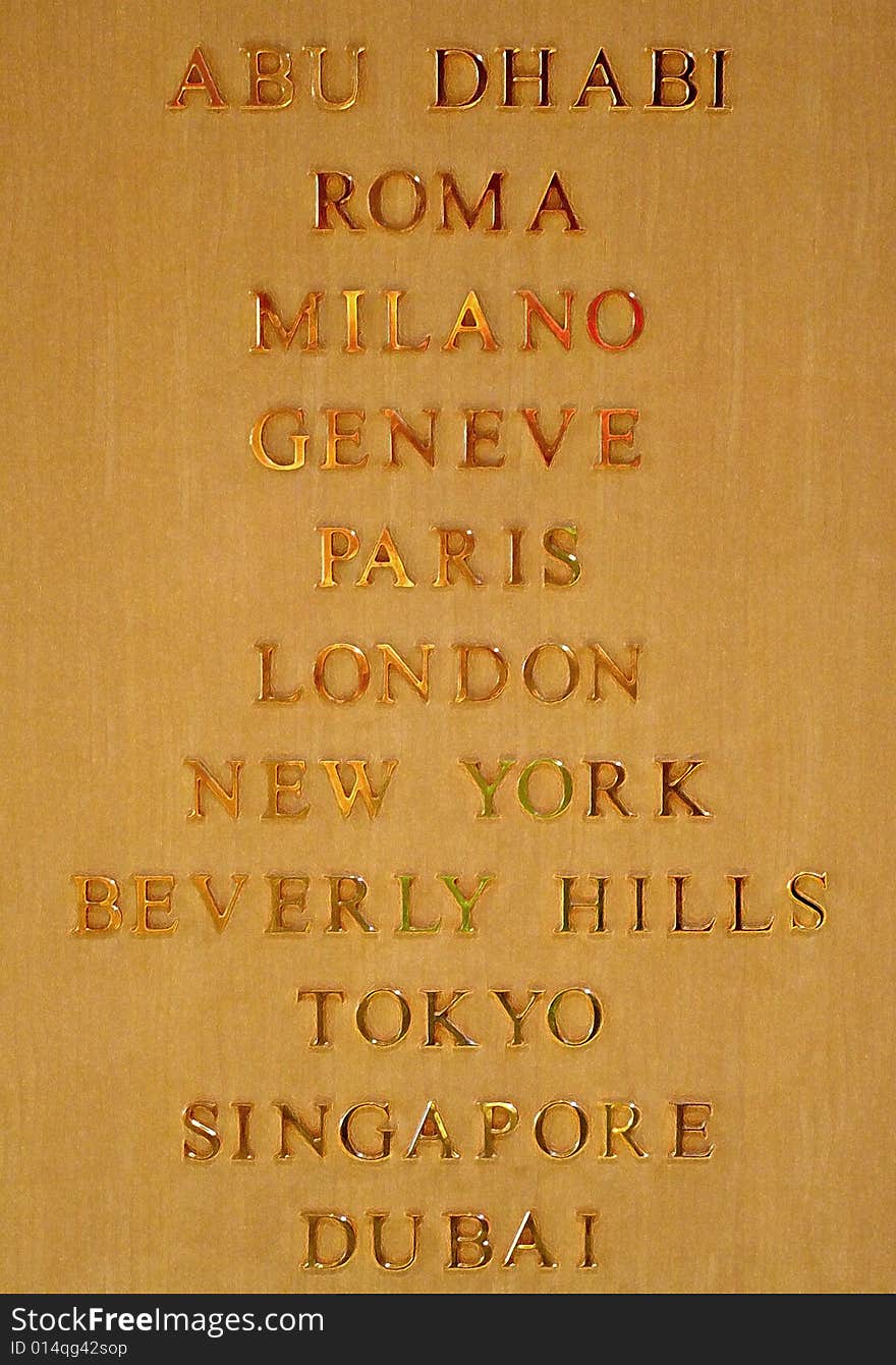 An image with famous city names on a wood surface in gold. An image with famous city names on a wood surface in gold.