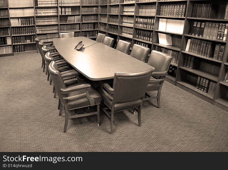 Conference room table with several leather chairs and shelves of books. Conference room table with several leather chairs and shelves of books