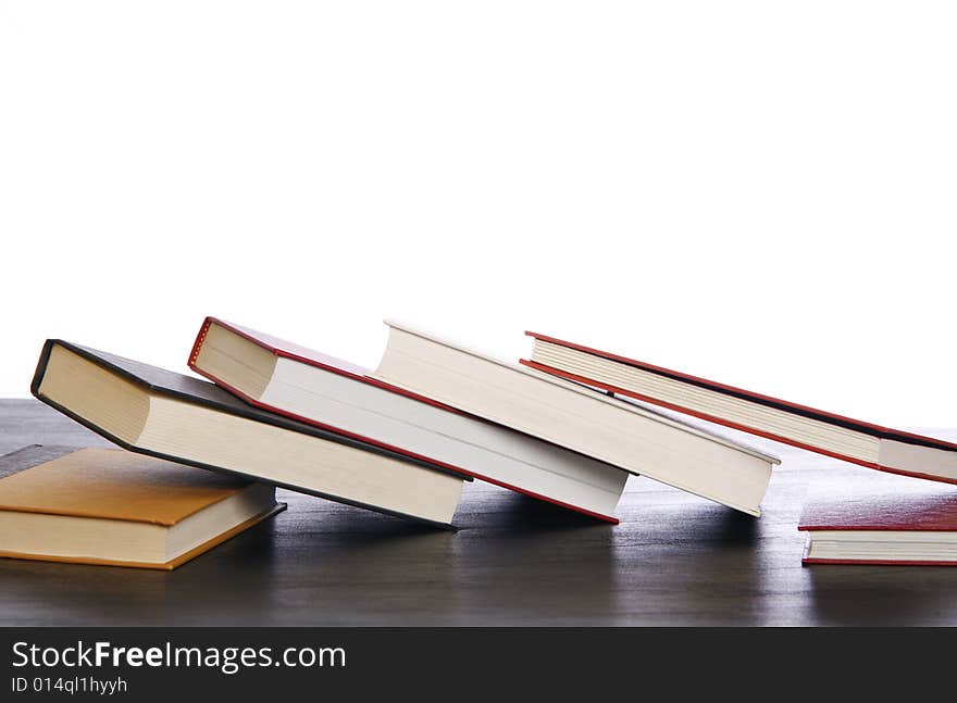 Various hardcover books angled on top of each other.