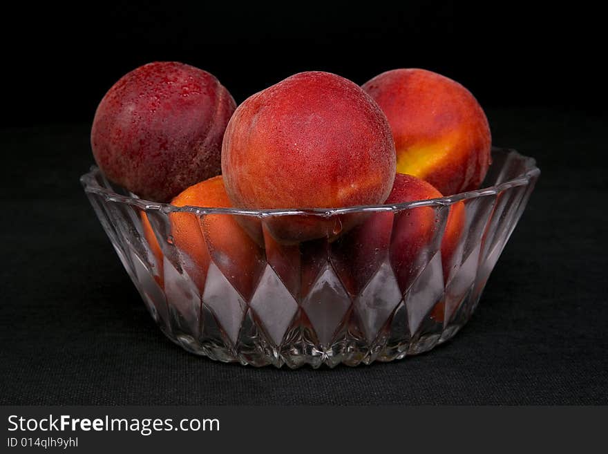 Shot of a freshly washed bowl of peaches in a crystal bowl.