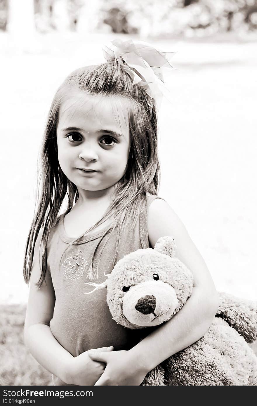 Beautiful little girl with her very best friend, her teddy bear, in tow in brown tones. Beautiful little girl with her very best friend, her teddy bear, in tow in brown tones.